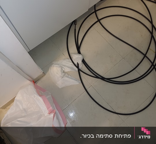 כבלים שחורים על רצפה ליד ארון מטבח